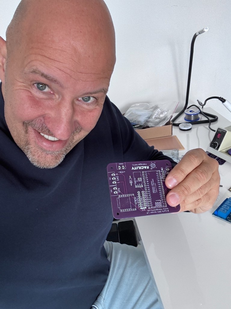 Attila Kasler holding a custom purple PCB
