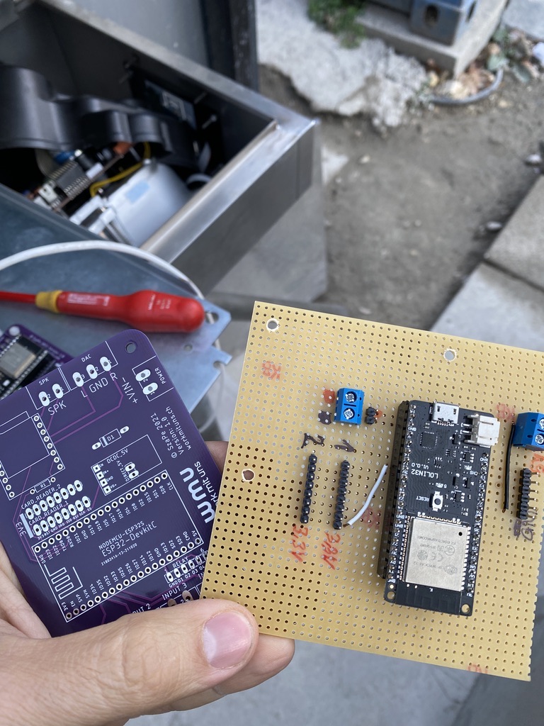 Custom purple PCB and prototype board with an ESP32 module, held in hand